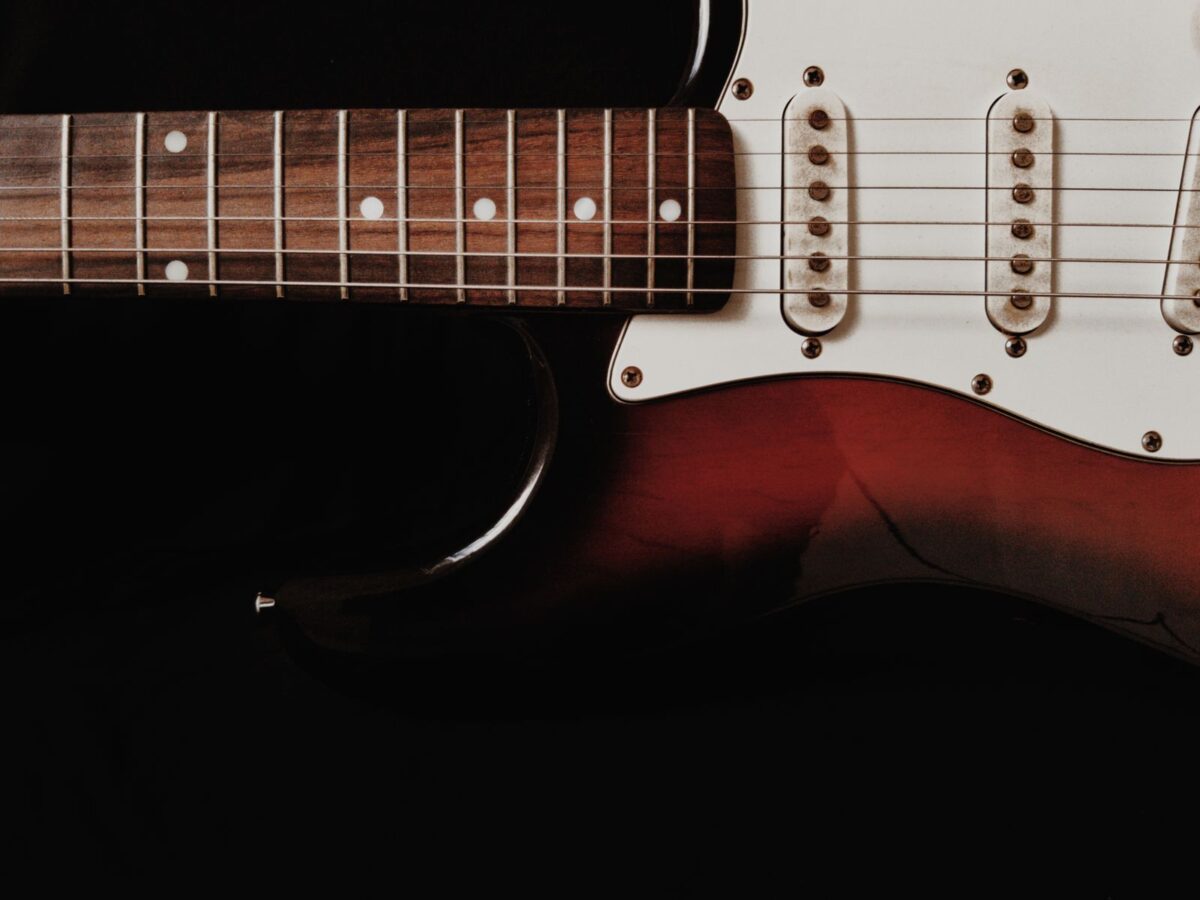Primer plano de una guitarra eléctrica sobre fondo oscuro
