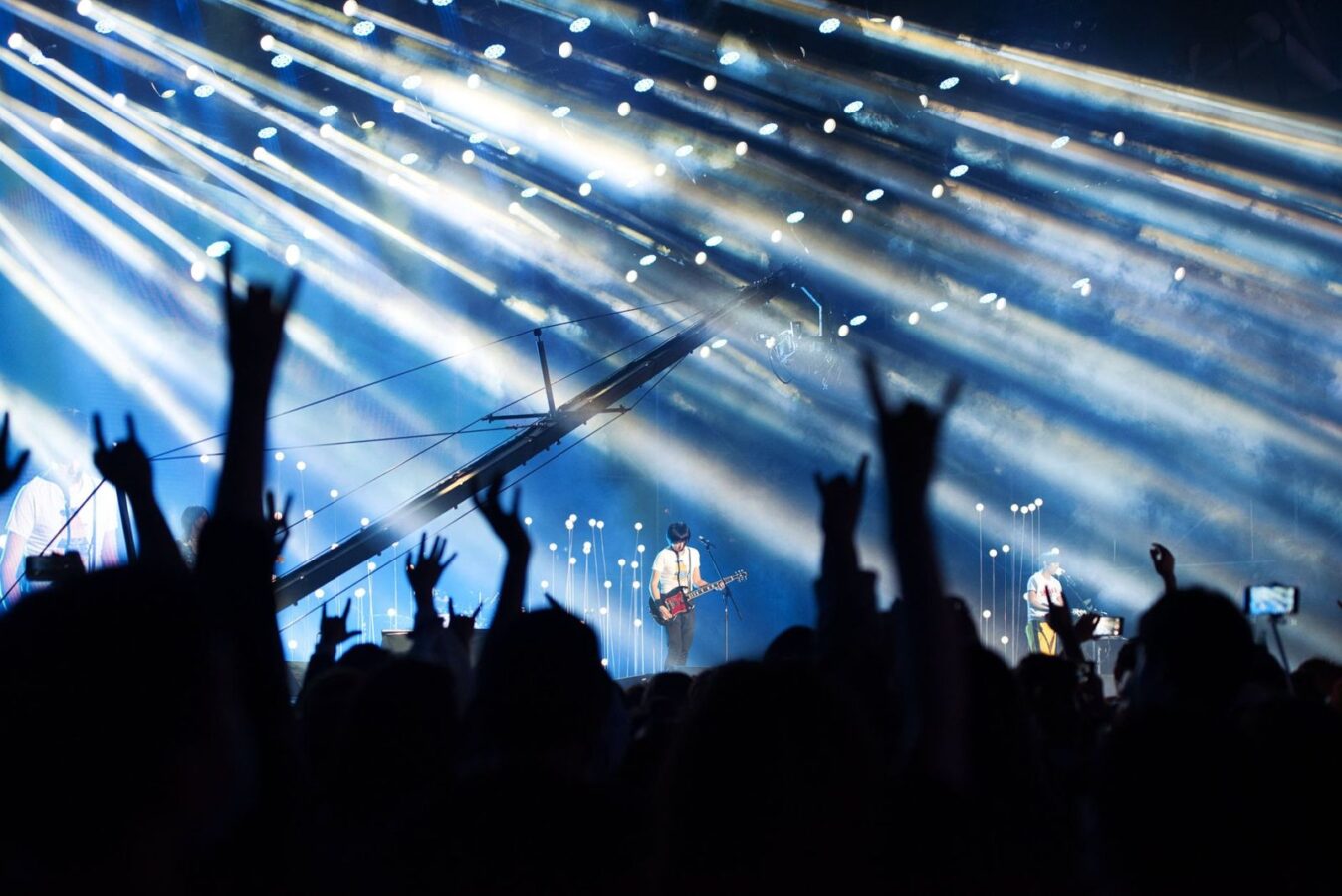 Crowd with hands raised in front of an illuminated stage