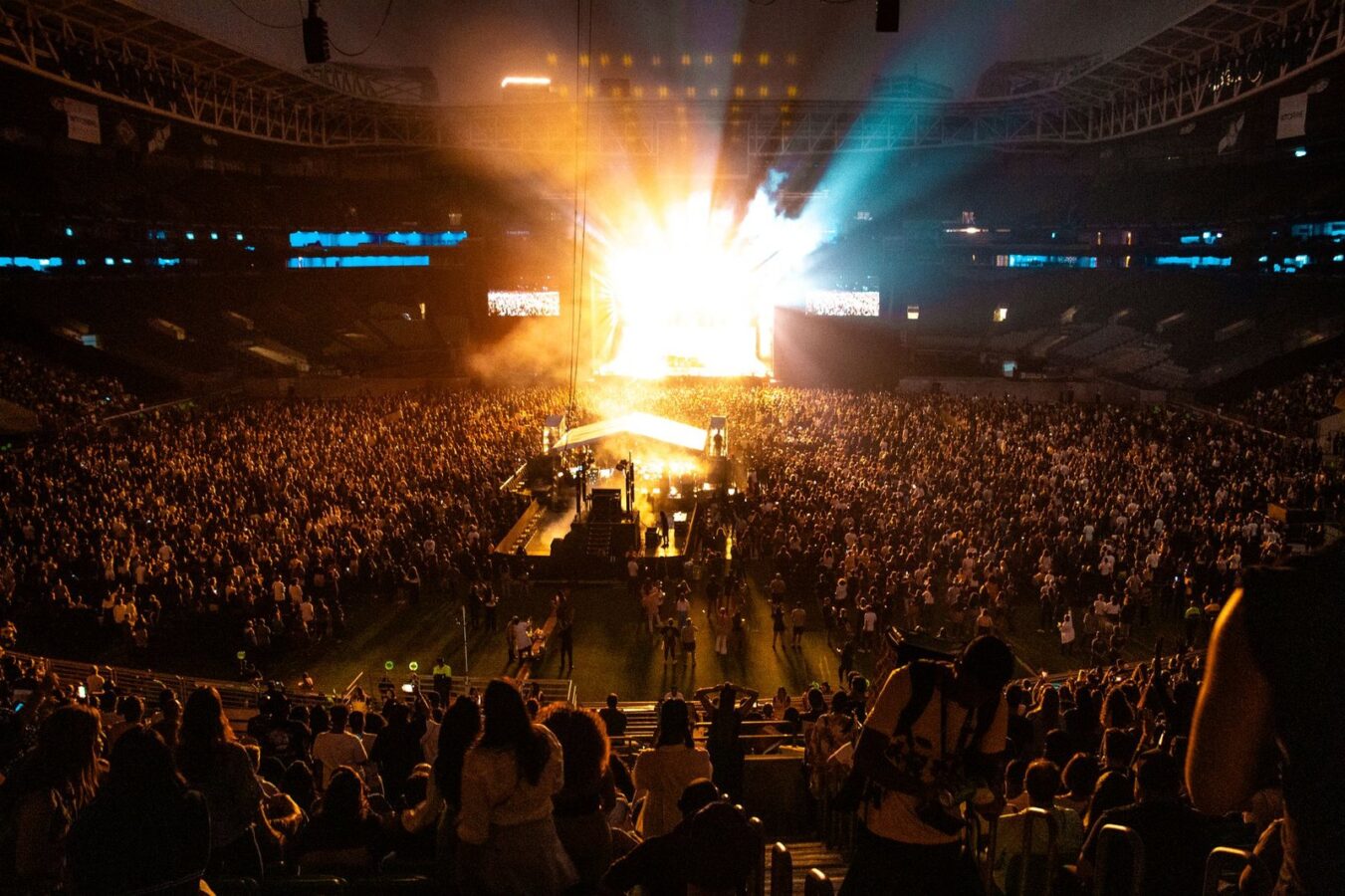 Estádio lotado diante de um palco iluminado