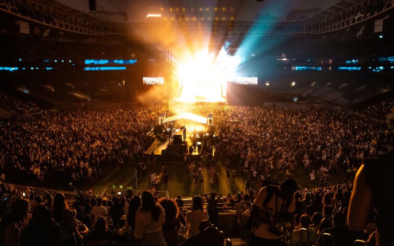 Packed stadium in front of an illuminated stage