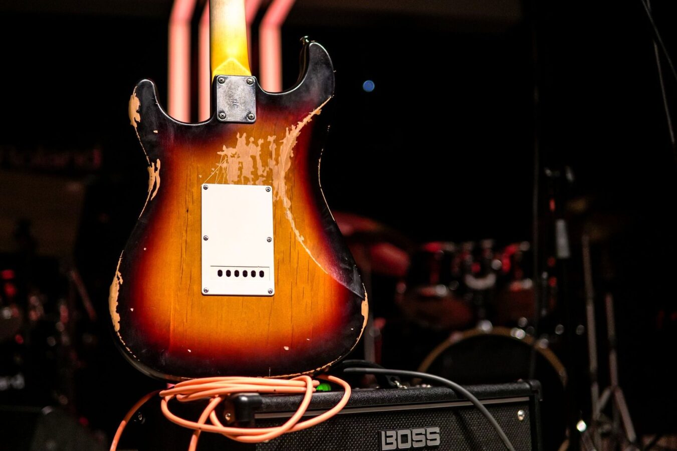 Vintage electric guitar resting on an amp on a stage