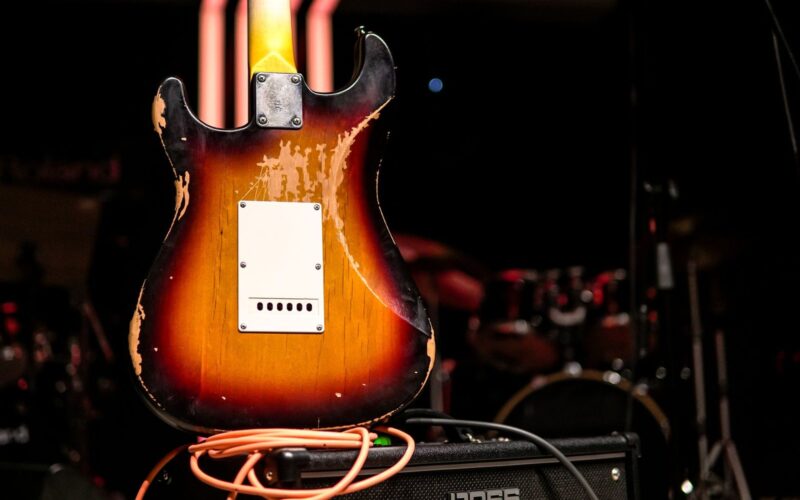 Guitarra elétrica antiga sobre um amplificador, em um palco